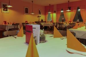un comedor con mesas y sillas con conos amarillos y naranjas en TOTO's Gasthaus, en Hattingen