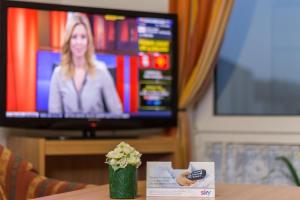 uma pessoa sentada à mesa em frente a uma televisão em TOTO's Gasthaus em Hattingen