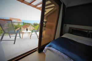ein Schlafzimmer mit einem Balkon mit einem Bett und einem Tisch in der Unterkunft Vila La ViTa del Mare in Bijela