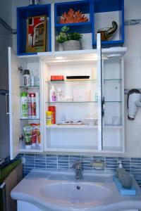 a bathroom with a sink and an open refrigerator at intero appartamento con giardino e colazione Dario in Parma
