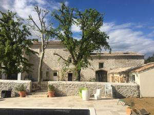 a stone house with a stone wall and a patio at gite le cabanon in Réauville