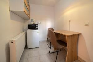 a small kitchen with a table and a small refrigerator at Gloria Apartments in Sighişoara