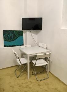 a white desk with two chairs and a tv on a wall at City Center AP 2 in Košice