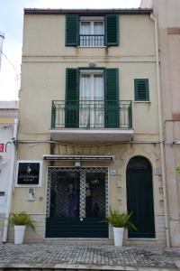 ein Gebäude mit grünen Rollläden und einem Fenster in der Unterkunft City house in Campofelice di Roccella