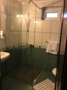 a bathroom with a shower with a glass door at Pensiunea Cerbul Carpatin in Bran +42 photos