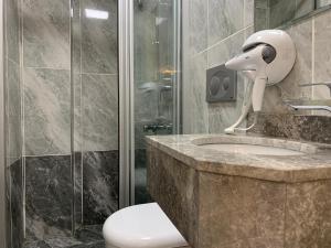 Un baño con inodoro, lavabo y ducha. en taksim diamond hotel, en Estambul 133 fotos más