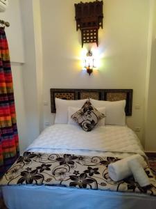 una camera da letto con un letto con un piumone bianco e nero di Dar Meknes Tresor a Meknès