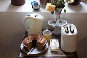 een tafel met een mixer en een taart op een bord bij Cork Hills Farmhouse in Monte da Pedra