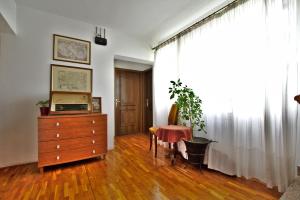 uma sala de estar com uma cómoda, uma mesa e uma janela em Apartments and Rooms Irena em Rovinj