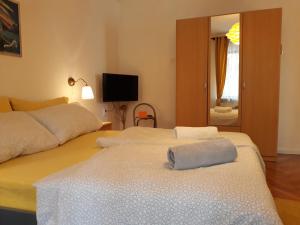 a bedroom with two beds and a tv and a mirror at Apartments Garden in Rovinj