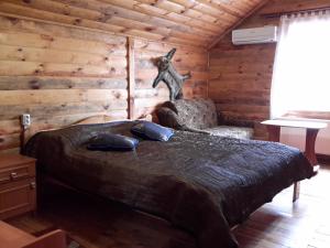 a bedroom with a bed in a log cabin at Садиба Лісова казка in Szack
