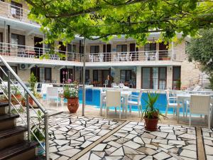 a patio with chairs and tables and a building at Alida Hotel in Pamukkale