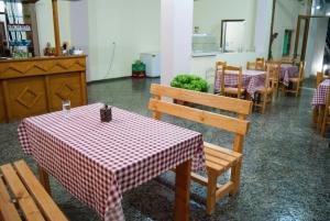 un restaurante con mesas y sillas con un mantel a cuadros rojo y blanco en Let Rooms Lukova, en Lukovë
