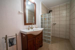 a bathroom with a sink and a shower with a mirror at Gloria Apartments in Sighişoara +55 photos