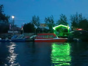 un bote rojo en el agua por la noche en Camping Casuta Mihaela, en Crisan