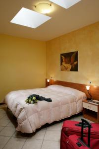a bedroom with a bed with flowers and luggage at Il Turrione in Assisi