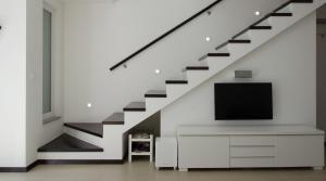 uma sala de estar com uma televisão e uma escada em PortoVita Residence em Portorož