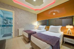 a hotel room with two beds and a window at Mersin Vip House Hotel in Mersin