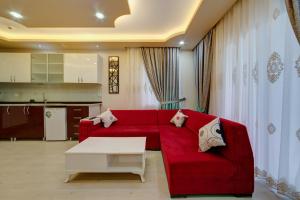 a living room with a red couch and a table at Mersin Vip House Hotel in Mersin