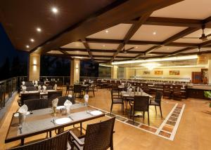 戈尔哈布尔Hotel Ayodhya的有桌椅和酒吧的餐厅