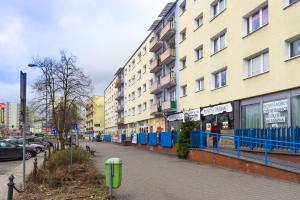 ulica miejska z wysokimi budynkami i chodnikiem w obiekcie Glamour Apartments w mieście Piła