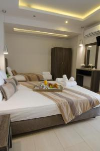 a hotel room with a large bed with a tray of food on it at Aparthotel Pagidas in Hanioti