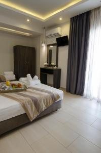 Cette chambre comprend un grand lit et une télévision. dans l'établissement Aparthotel Pagidas, à Chaniotis