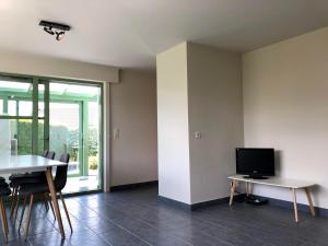 a living room with a tv and a table and chairs at Nieuwendamme 80 in Nieuwpoort