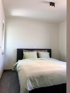 a bedroom with a large bed with white walls at Nieuwendamme 80 in Nieuwpoort +27 photos