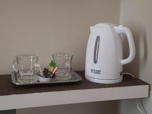 a tea kettle and glasses on a shelf at Art in B&B in Salerno