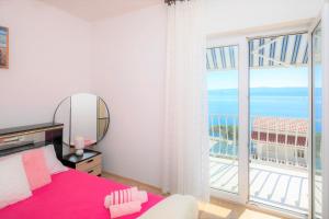 1 dormitorio con cama y ventana grande en FBA Family Beach Apartments, en Omiš
