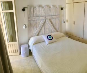 a bedroom with a bed with a wooden door at Cycladic House in Naousa