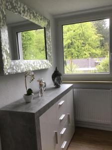 a kitchen with a dresser with a mirror and two windows at Haus Manuela in Velden am Wörthersee