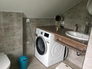 a bathroom with a washing machine and a sink at Haus Manuela in Velden am Wörthersee +1 photo