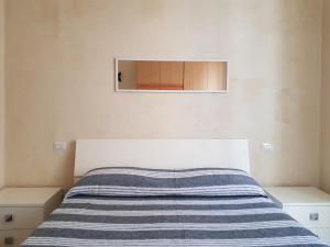 a bed with a blue and white striped blanket on it at Casa Luciana in Savona