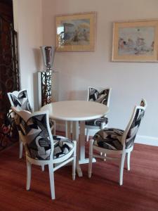 comedor con mesa blanca y sillas en Hôtel Maïtagaria, en Biarritz