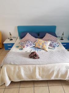 a bed with a blue headboard and pillows on it at Villa Amalfi in Amalfi