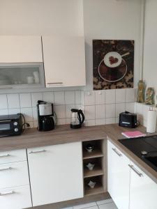 eine Küche mit weißen Schränken und einer Arbeitsplatte in der Unterkunft Wohnung in Hannover Zentrum in Hannover