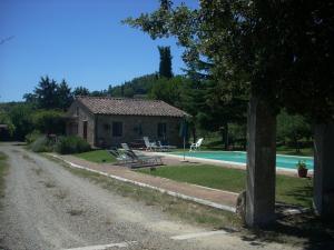 una pequeña casa junto a una piscina en Agriturismo Il Pratone, en Castiglione dʼOrcia