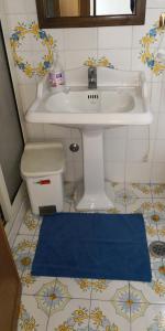 łazienka z umywalką i niebieskim dywanem w obiekcie Villaggio "Camping Pompei" w mieście Pompeje