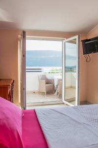 a bedroom with a bed and a view of the ocean at Apartments Mako in Herceg-Novi