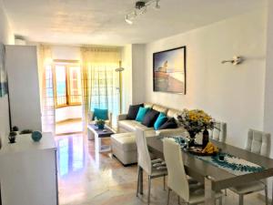 uma sala de estar com uma mesa e um sofá em Apartamento con vistas em Fuengirola