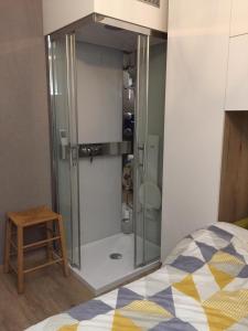 - une douche en verre dans une chambre avec un lit dans l'établissement 33 Paveestraße, à Eupen