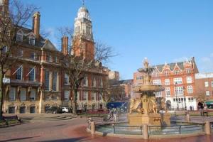 a fountain in front of a building with a clock tower at Studio flat in Leicester