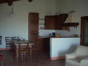 Una cocina y un comedor con mesa y sillas. en Agriturismo Il Pratone, en Castiglione dʼOrcia