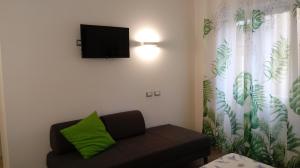 sala de estar con sofá y TV de pantalla plana en Travel House, en La Spezia