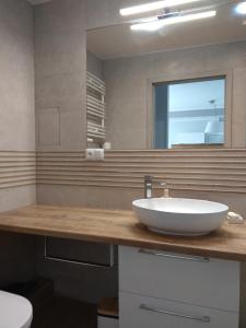 a bathroom with a white sink and a mirror at Apartament Cesarski Agnes in Świnoujście