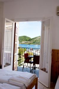 sypialnia z balkonem z widokiem na ocean w obiekcie Hotel Christina w mieście Skiatos