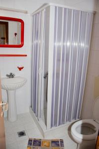 y baño con ducha, aseo y lavamanos. en Hotel Christina en Skíathos