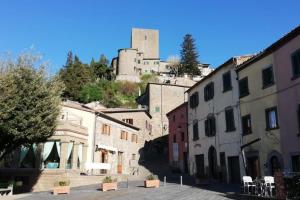 um grupo de edifícios com um castelo ao fundo em Le civette em Montecatini Val di Cecina